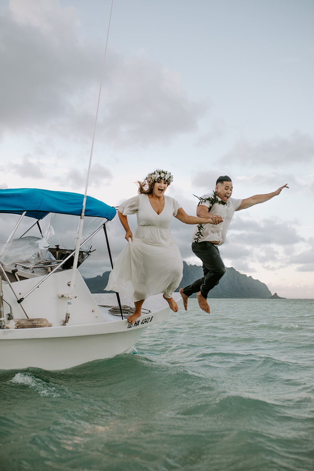 bride and groom jumping into ocean