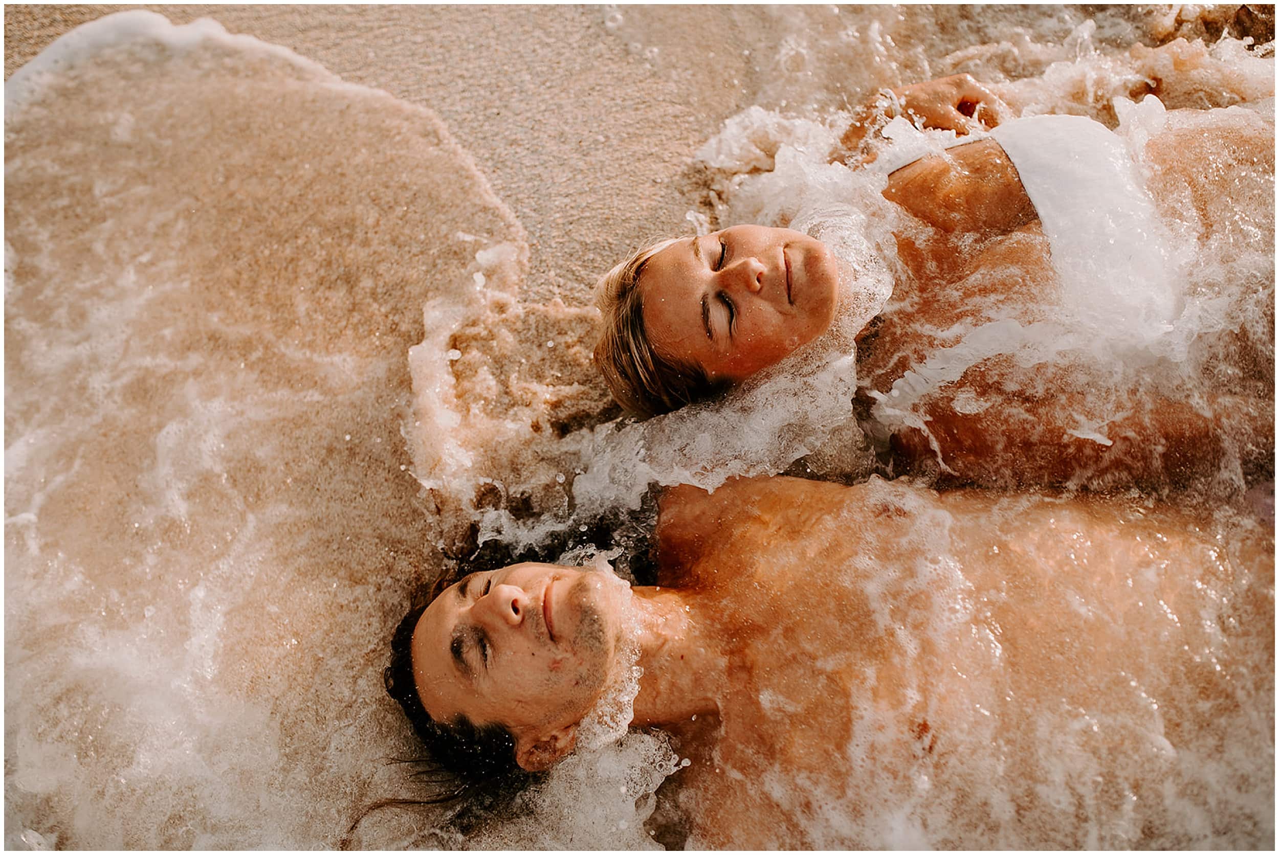 couple laying in ocean