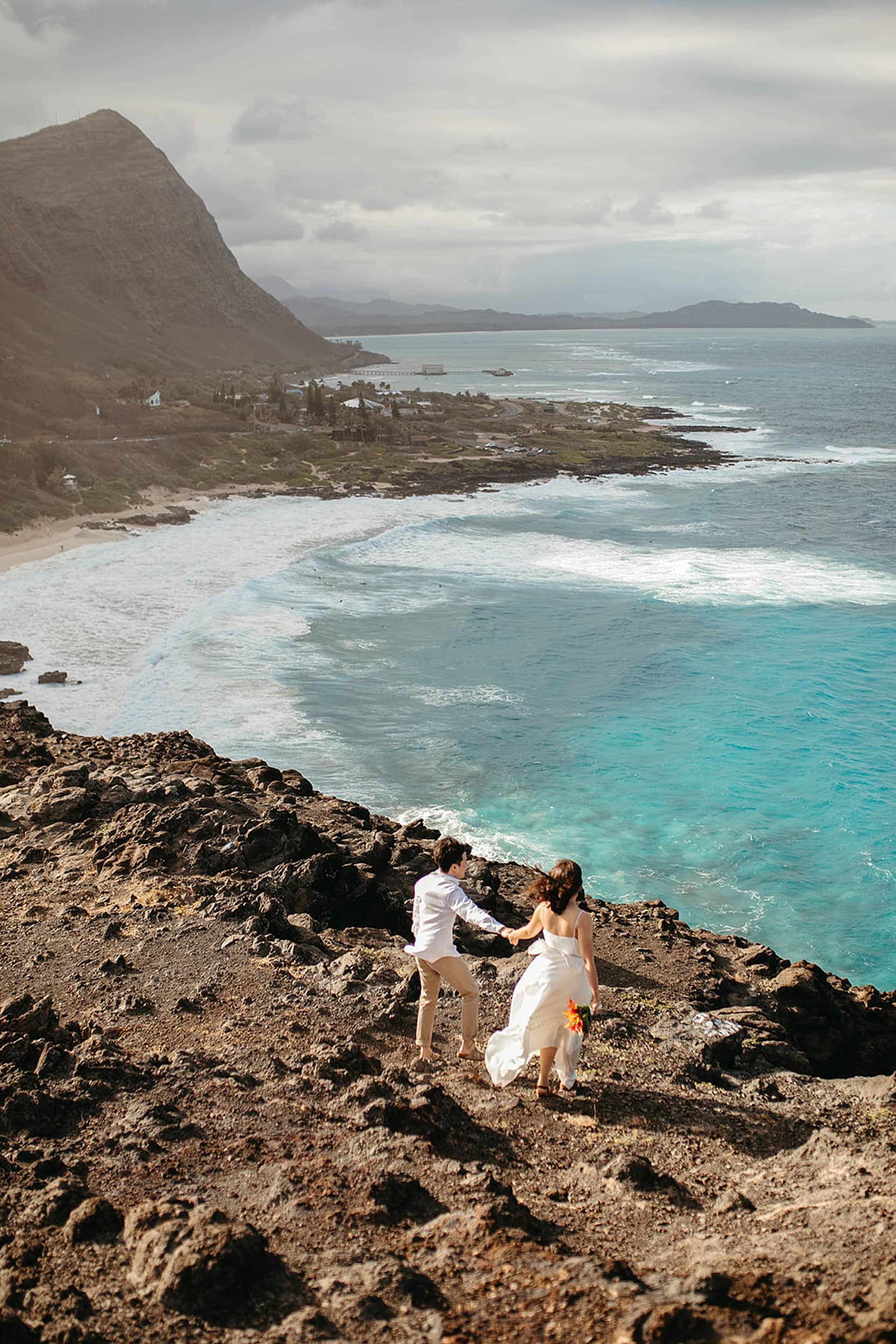 couple walking on a cliff during an Oahu elopement