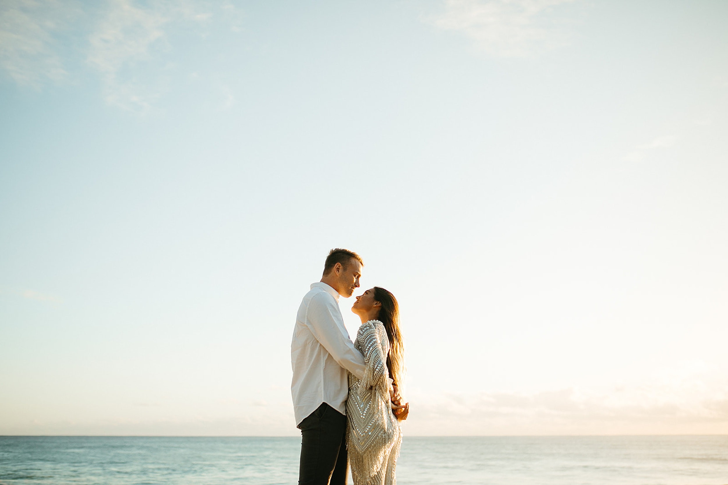 couple embracing on a beach in Oahu