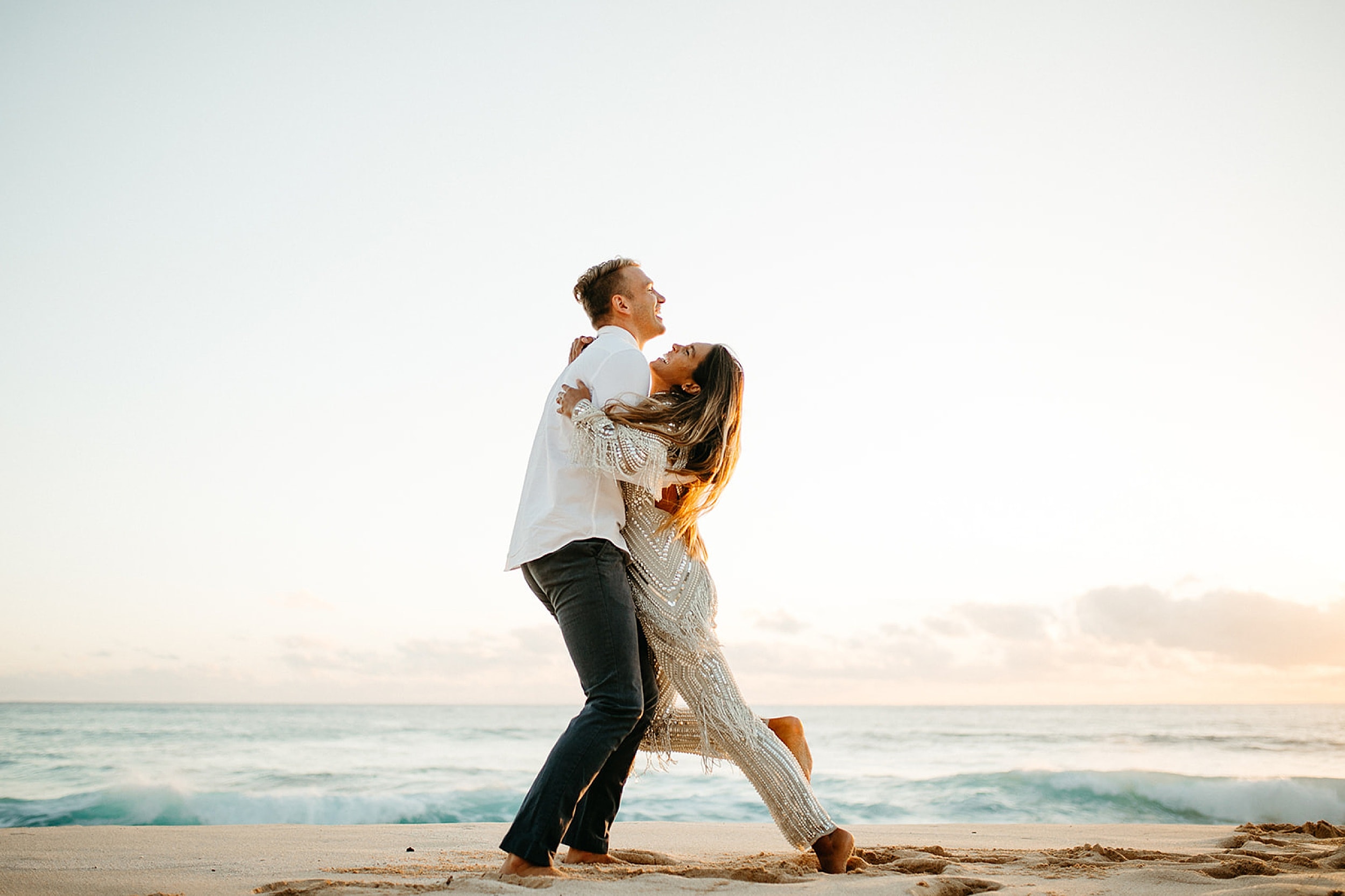 couple embracing on a beach in Oahu