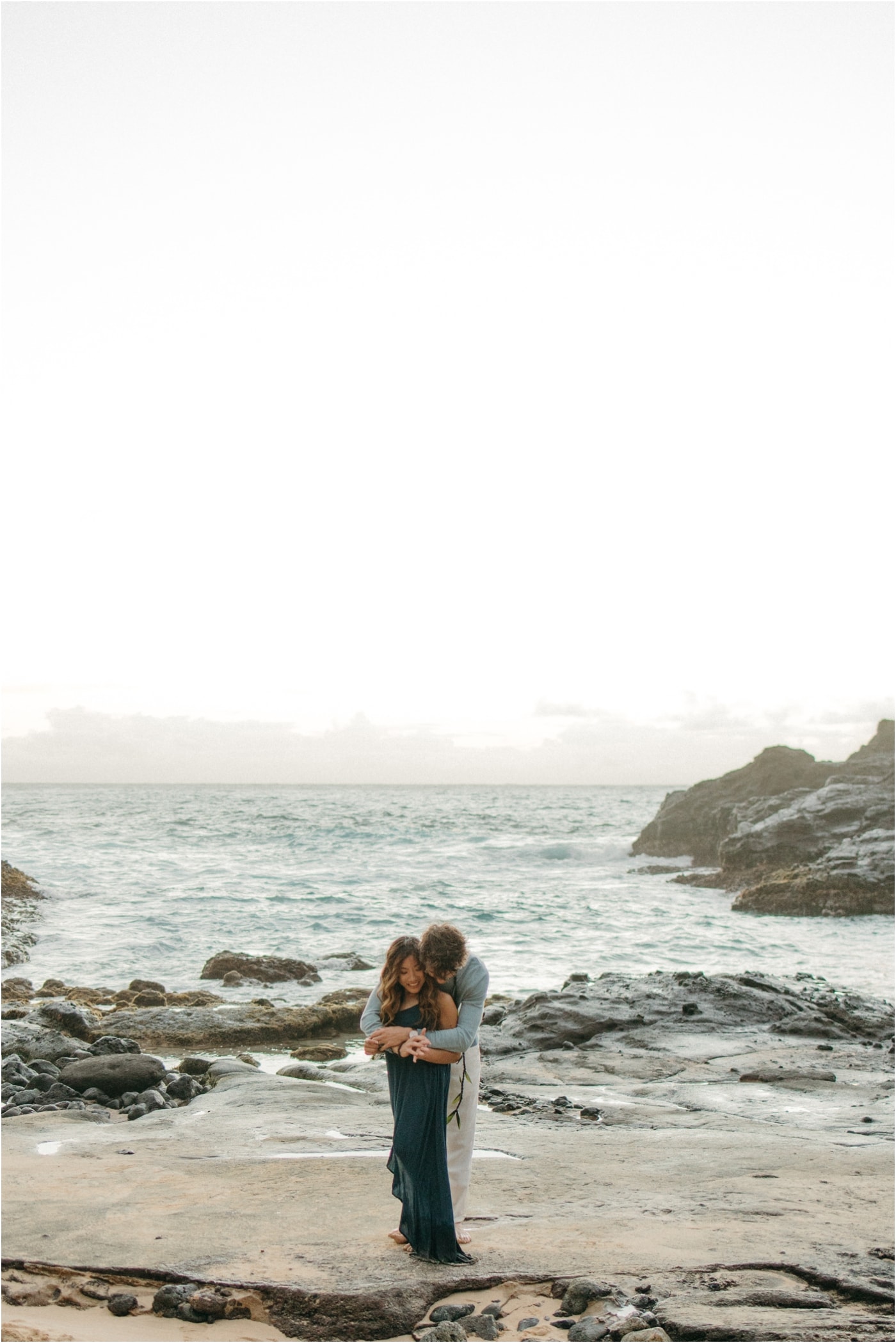 Couple embracing on a private beach in Oahu at sunset