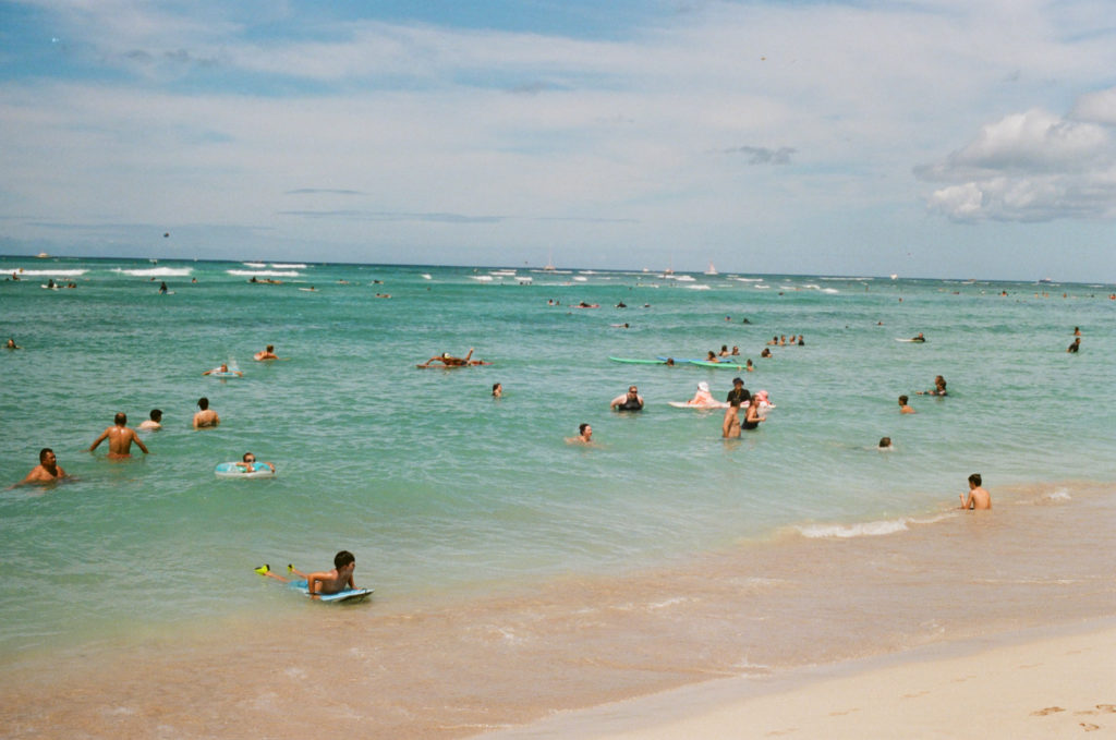 film picture of surfers and people in the water of the waikiki beach