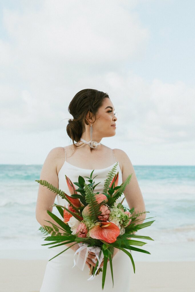 portrait of the bride holding her bouquet on the beach
