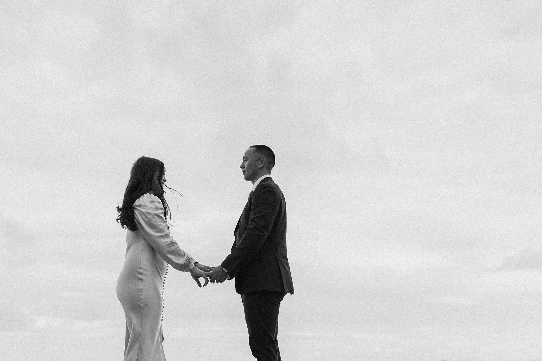black and white photo of the couple holding hands, facing eachother