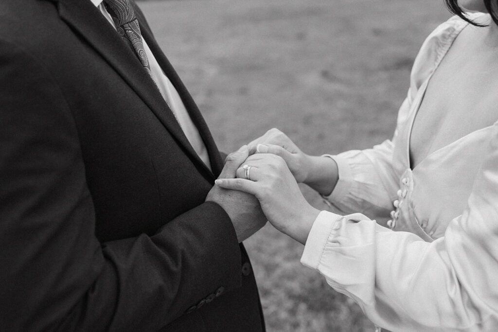 black and white photo focused on the couple holding hands