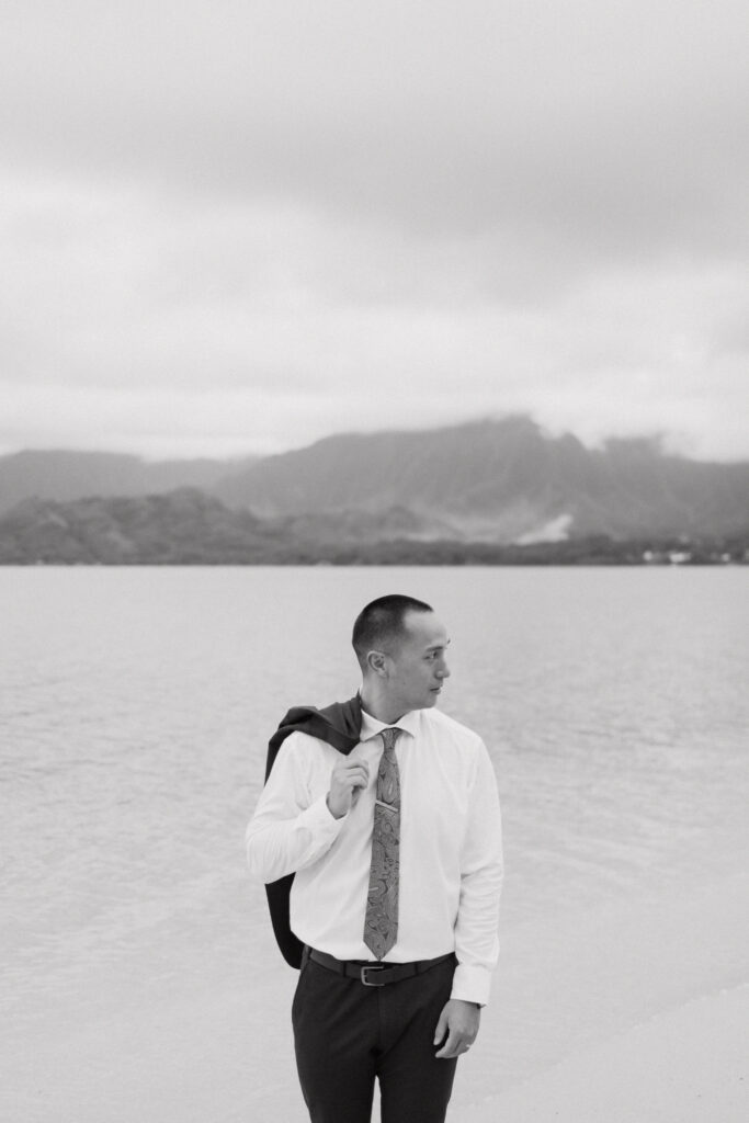 black and white photo of hao with his suit jacket over his shoulder