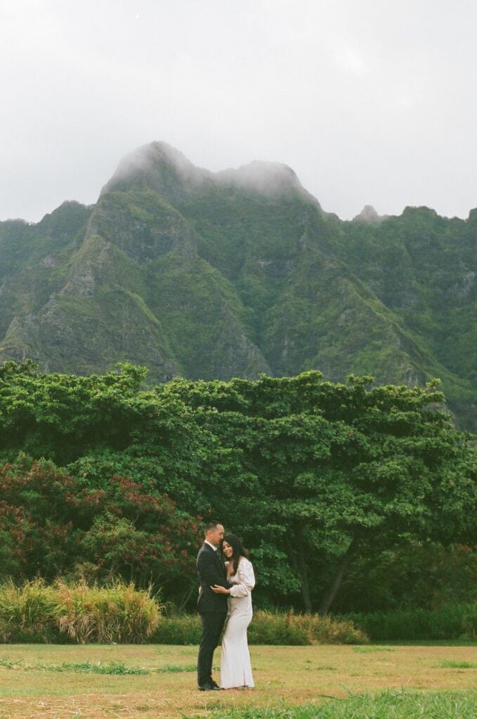 film photo of couple hugging in front of mountain scenery