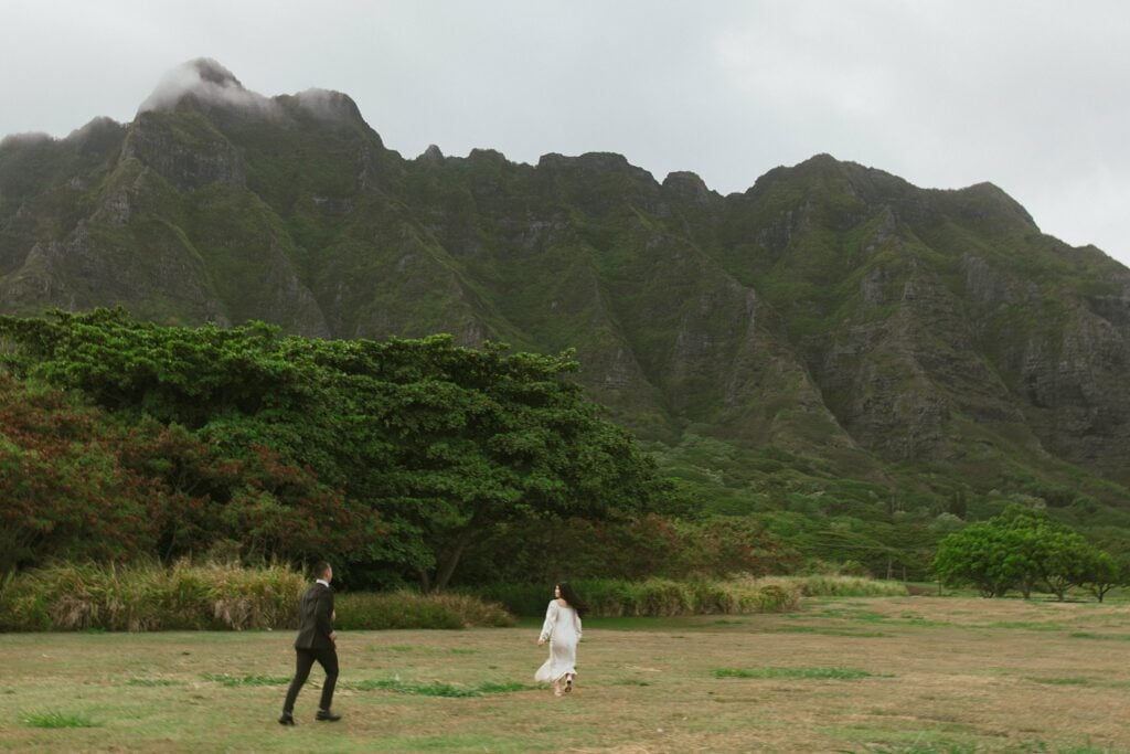 couple is walking toward green mountains