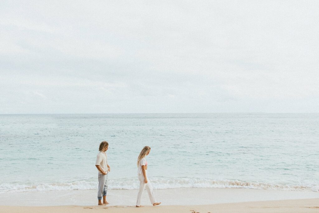 couple is walking along the beach together