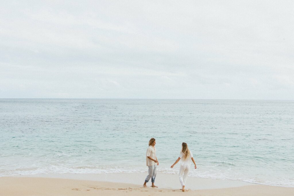 couple is walking along the beach with eachother