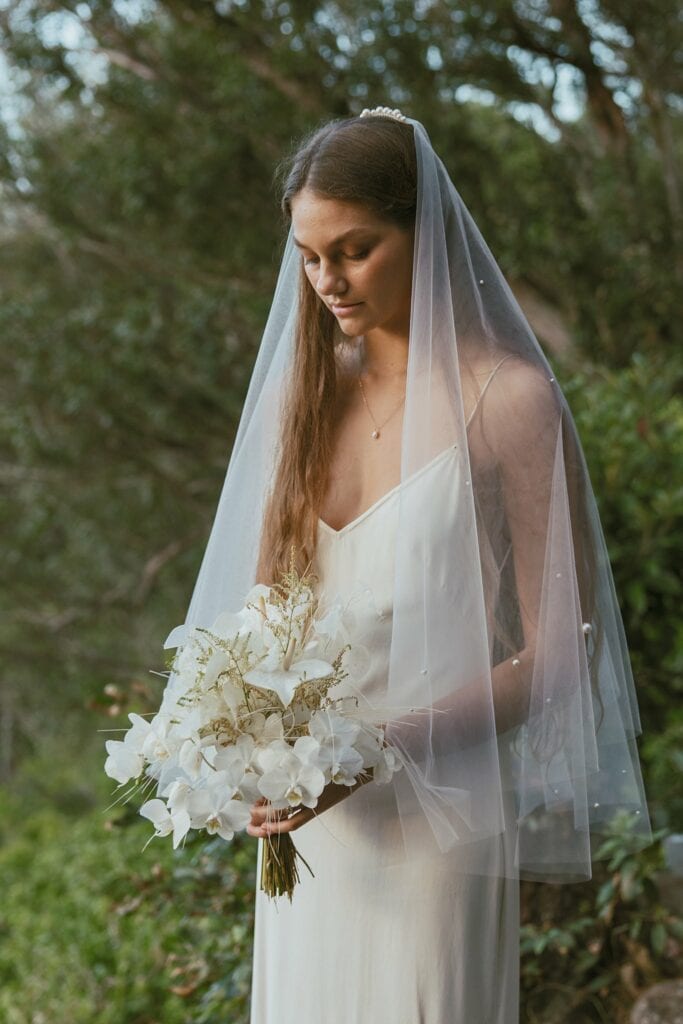 portrait shot of the bride with looking at her bouquet