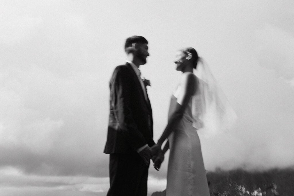 blurry black and white photo of bride and groom holding hands at their zero-waste wedding