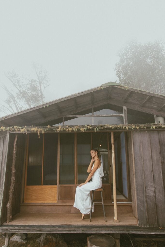 shot of bride sitting outside the cabin