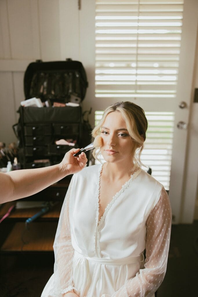 bride sitting in her chair getting her makeup done