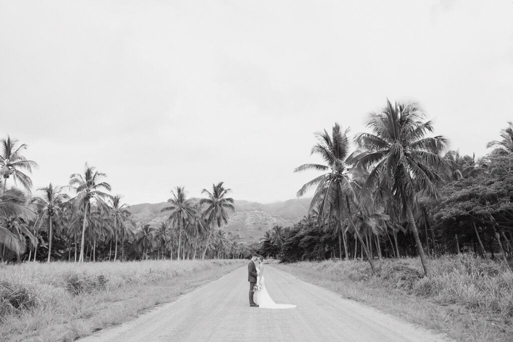 black and white shot of bride and groom on the dirt road