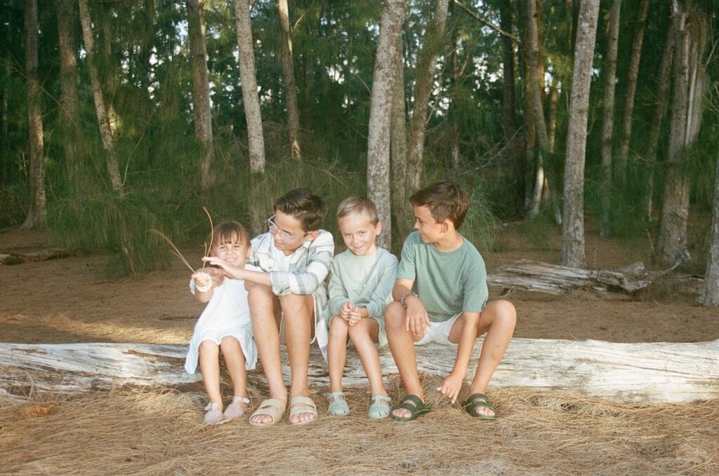 shot of kids sitting on a log