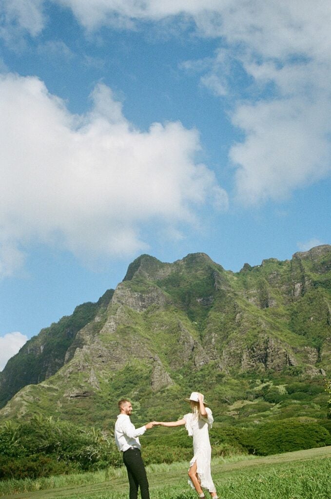 couple is holding hands in front of the mountains