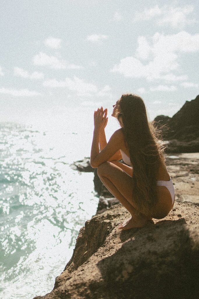 film photo of model crouching on a rock