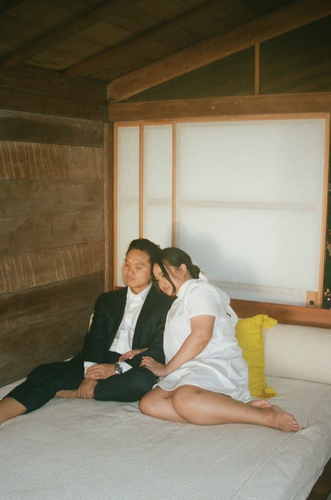 film photo of the couple kissing on a bed