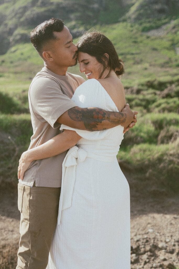 couple is hugging in front of the mountain