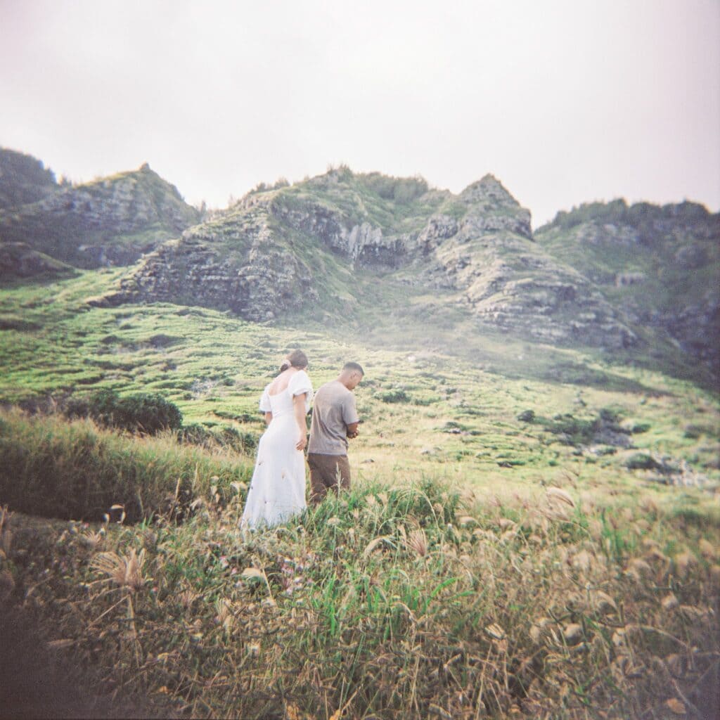 film photo of the couple walking together along the mountain range